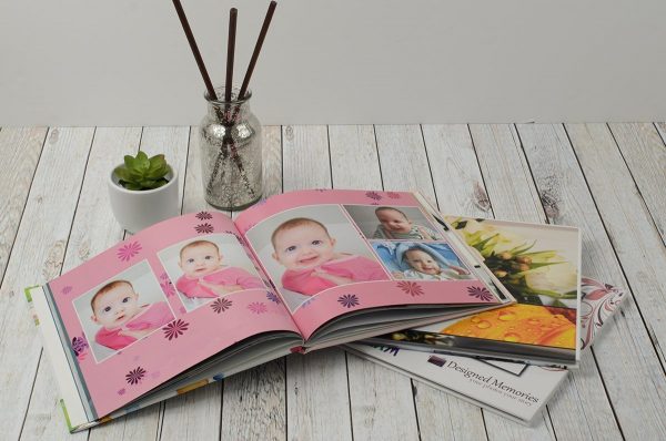 Annual family photobook showing smiley baby with pink background